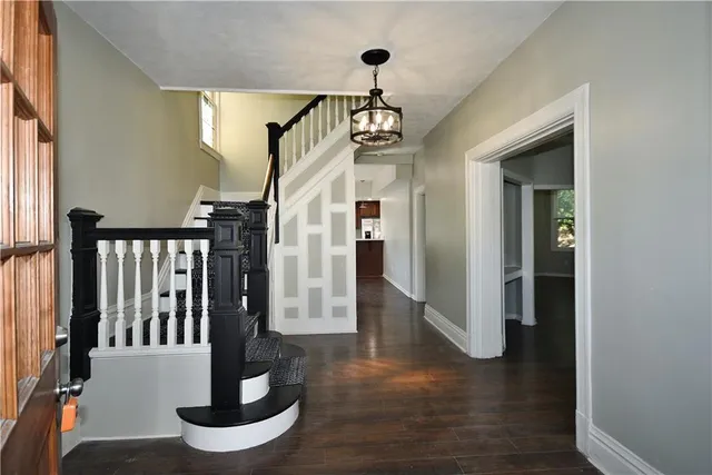 a view of a hallway with wooden floor and staircase