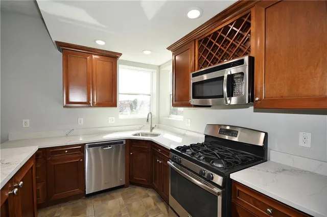 a kitchen with stainless steel appliances a sink dishwasher stove microwave and cabinets