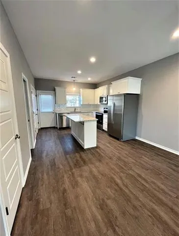 a view of kitchen with refrigerator stove and wooden floor