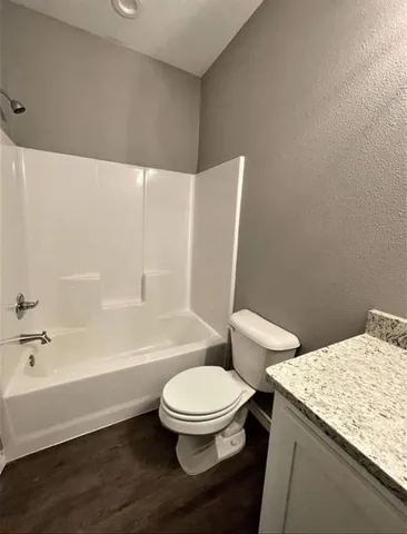 a bathroom with a granite countertop toilet a sink and bathtub