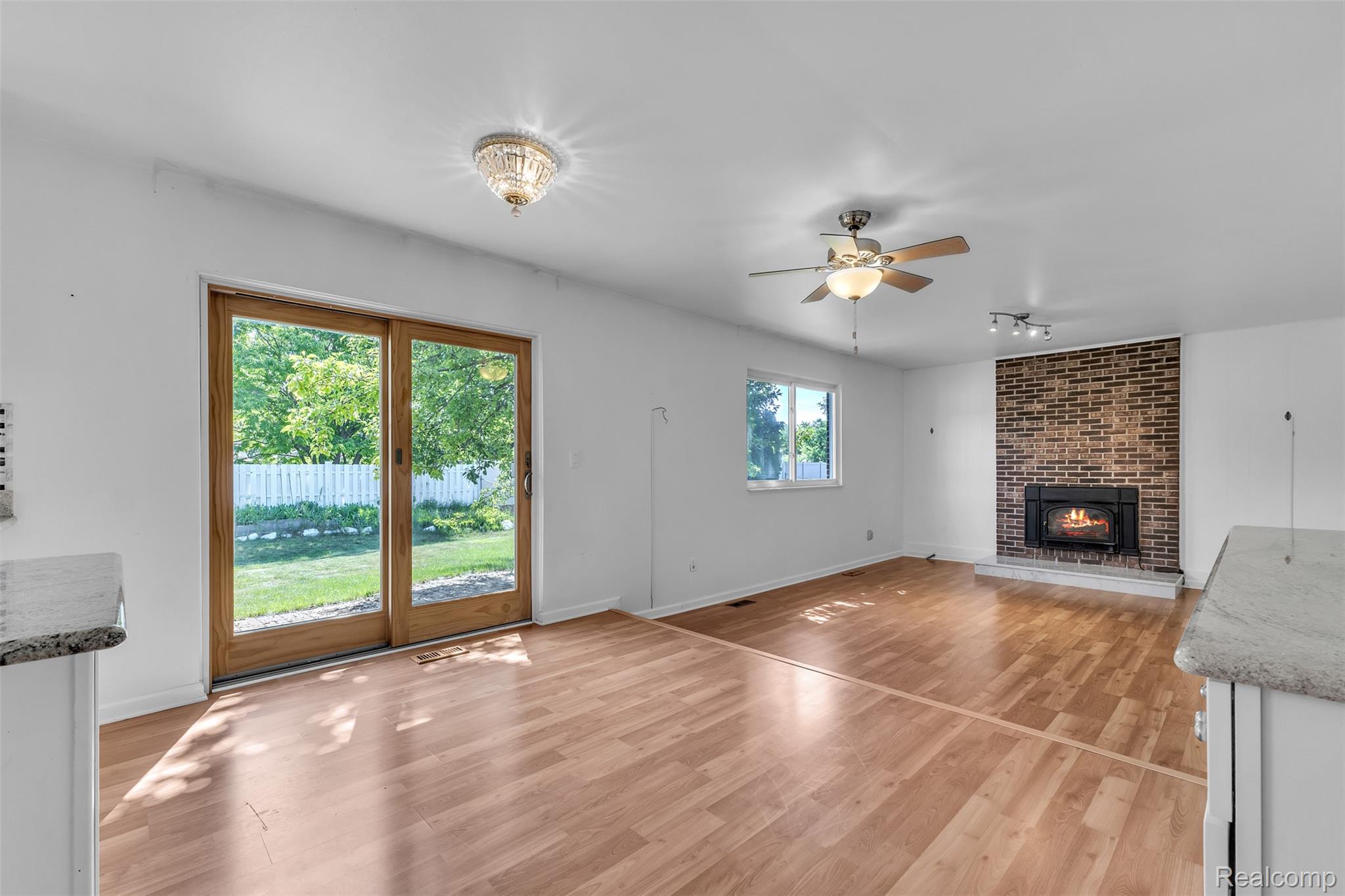 7000 Woonsocket Street Canton, MI 48187 - Photo 25 of 65 Living area featuring wood-finish flooring, a brick fireplace, and a ceiling fan