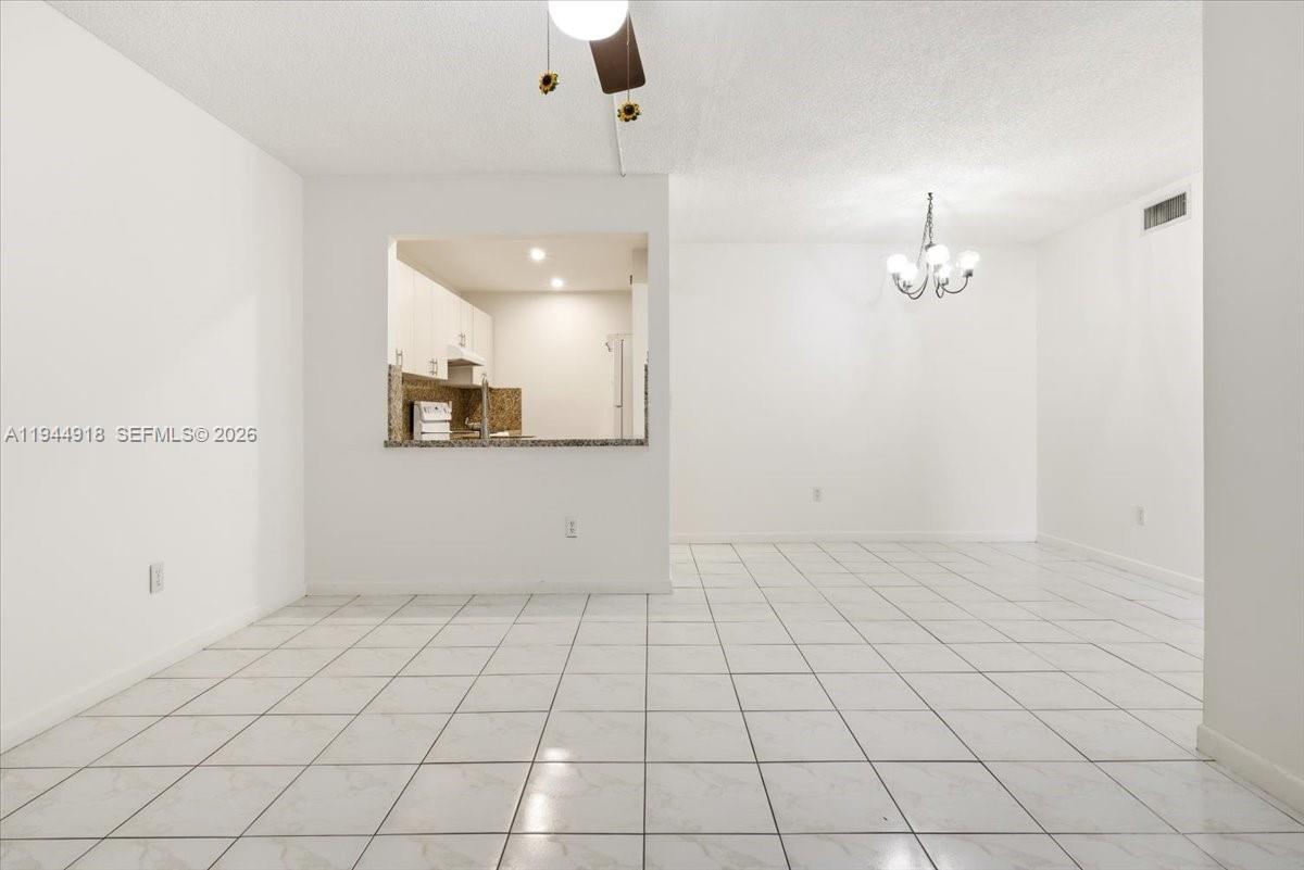 14861 Southwest 104th Street, Unit 2813 Miami, FL 33196 - Photo 5 of 21 an empty room with kitchen view and mirror
