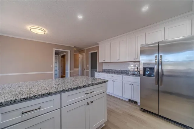 a kitchen with granite countertop cabinets stainless steel appliances and a counter space