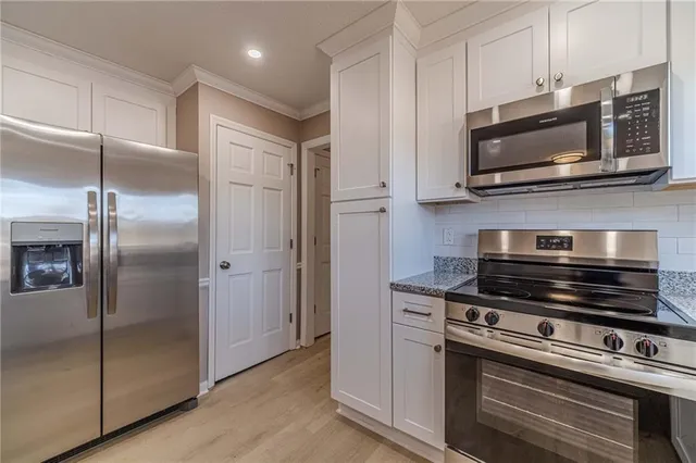 a kitchen with stainless steel appliances and chandelier