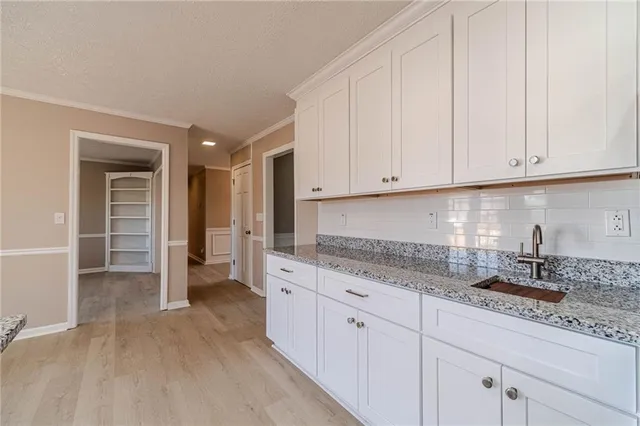 a kitchen with granite countertop a sink and cabinets