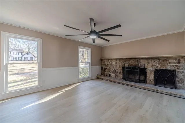 a view of an empty room with window and fire place