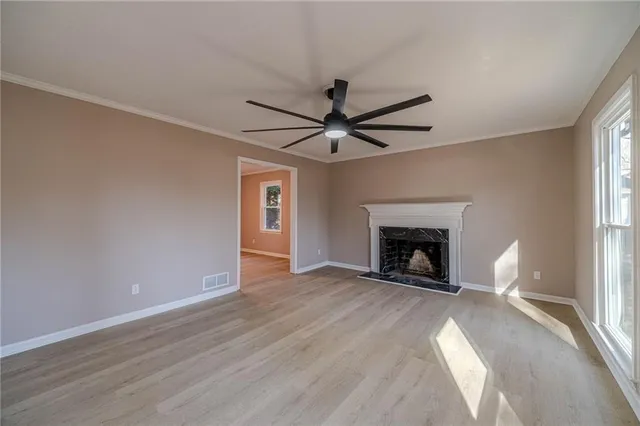 a view of an empty room with window and fire place