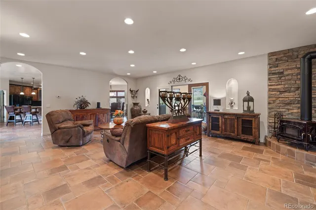 a living room with furniture a flat screen tv and kitchen view