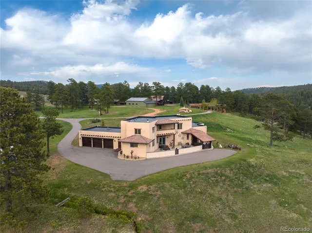 an aerial view of a house with outdoor space swimming pool and mountains