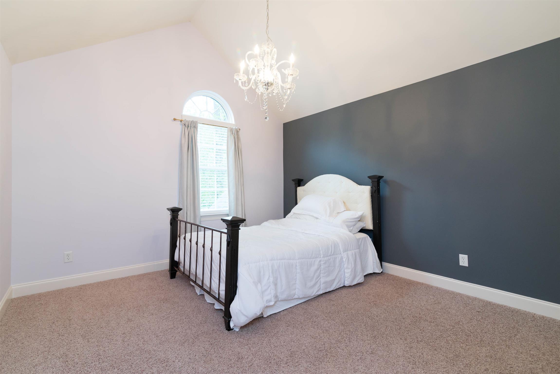 623 Tulip Grove Road Hermitage, TN 37076 - Photo 17 of 30 a bedroom with a bed and a chandelier