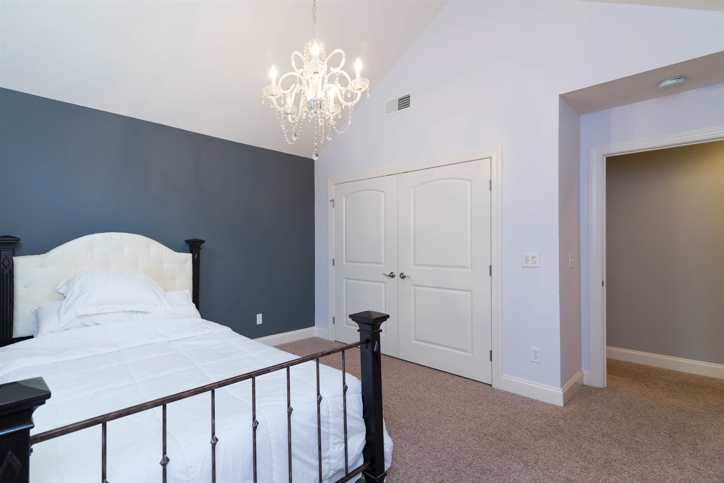 623 Tulip Grove Road Hermitage, TN 37076 - Photo 18 of 30 a bedroom with a bed and a chandelier