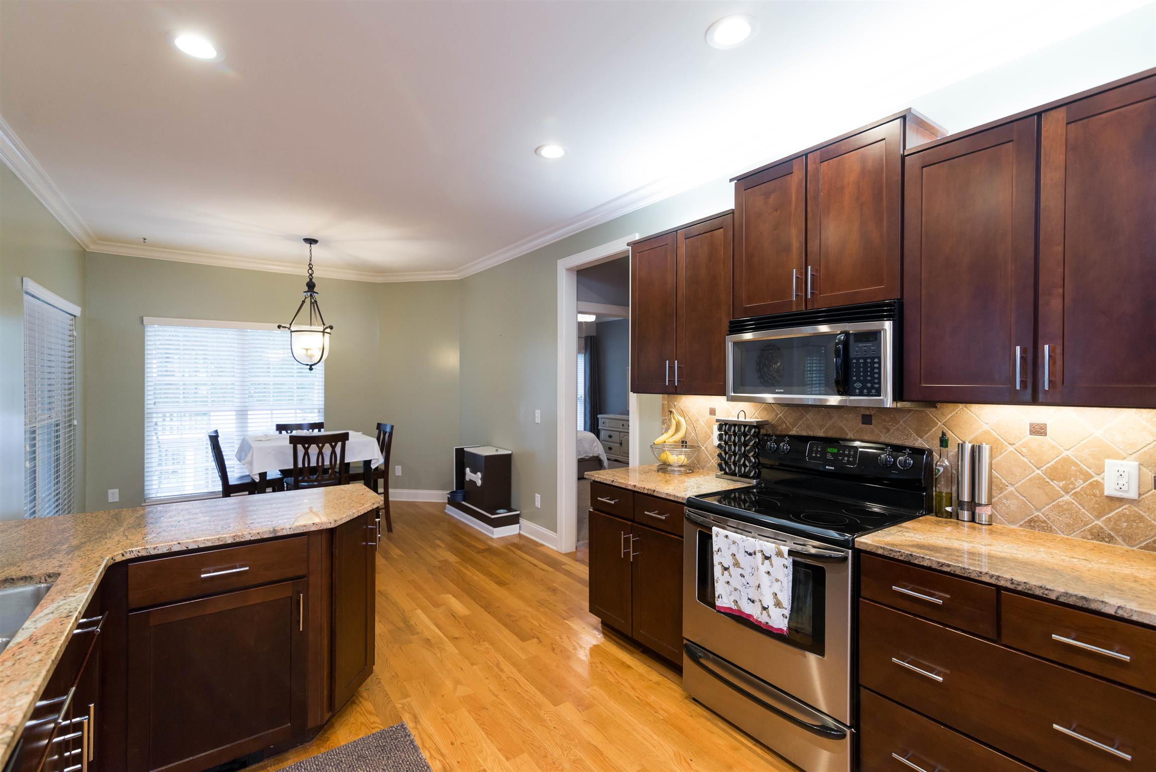 623 Tulip Grove Road Hermitage, TN 37076 - Photo 9 of 30 a kitchen with granite countertop wooden cabinets and black appliances