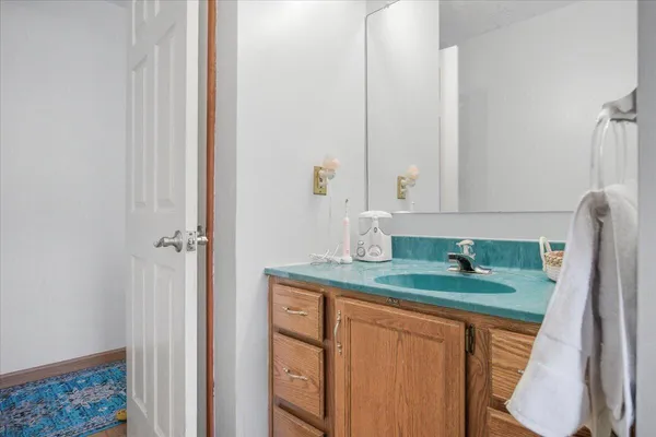 a bathroom with a granite countertop sink and a mirror