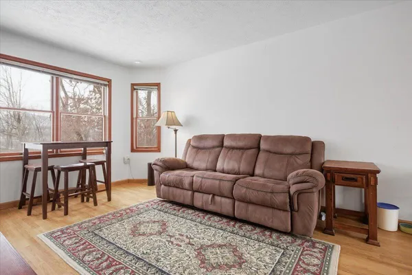 a living room with furniture a rug a lamp and a table