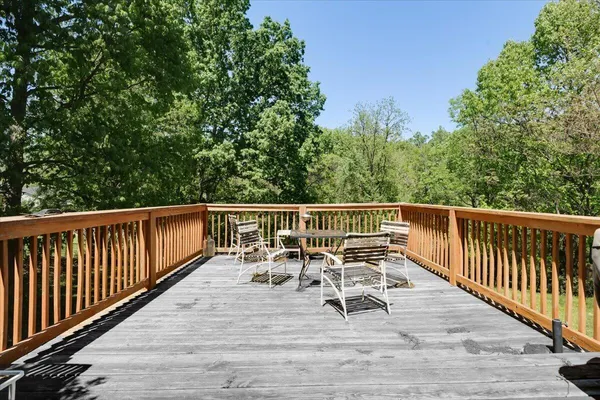 a view of a deck with two chairs and wooden floor