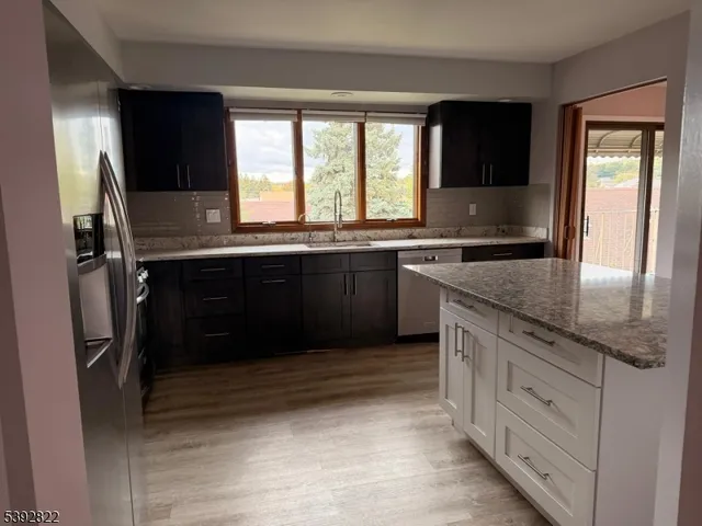 a kitchen with granite countertop a refrigerator and a sink