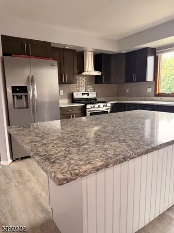 a kitchen with granite countertop a refrigerator and a sink