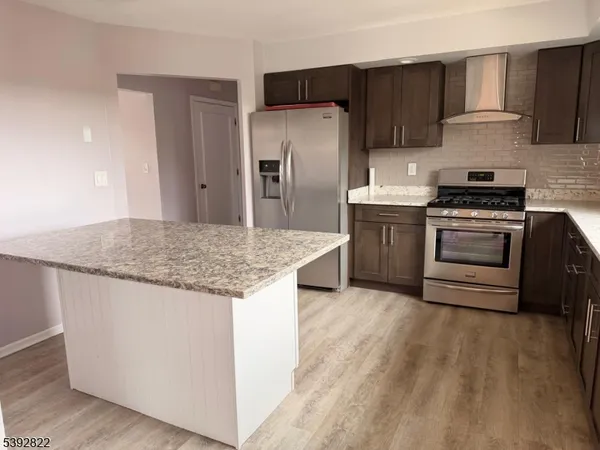 a kitchen with stainless steel appliances granite countertop a stove a refrigerator and a sink
