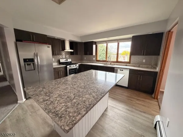 a kitchen with stainless steel appliances granite countertop a sink refrigerator and stove