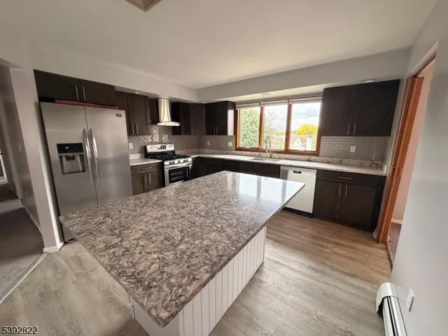 a kitchen with stainless steel appliances granite countertop a sink refrigerator and stove