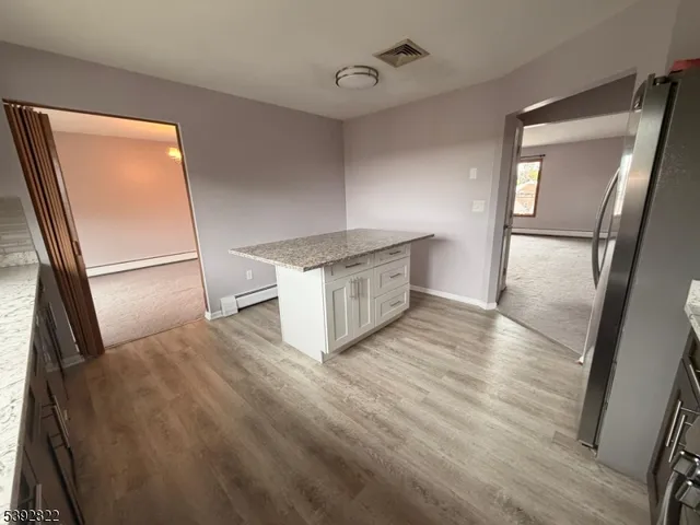 a kitchen with stainless steel appliances a refrigerator sink and wooden floor