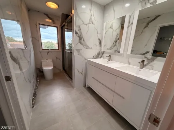 a bathroom with a double vanity sink toilet and a tub