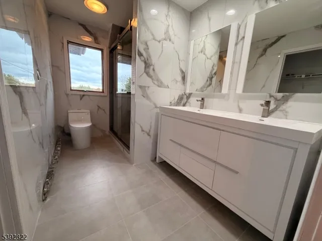 a bathroom with a double vanity sink toilet and a tub