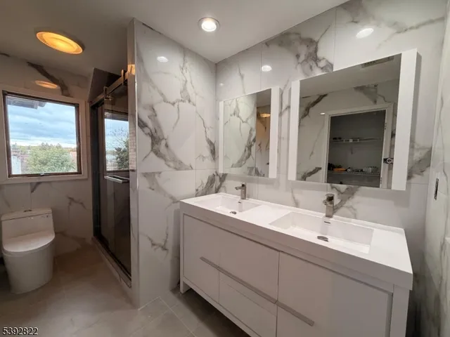 a bathroom with a double vanity sink mirror and toilet