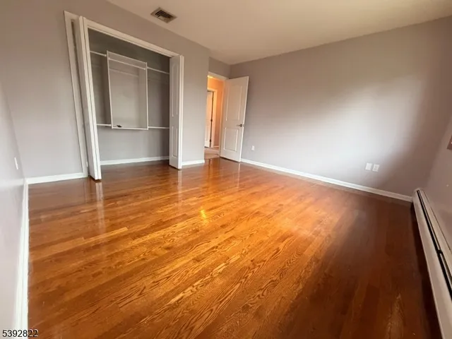 an empty room with wooden floor and door