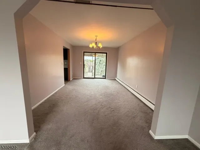 an empty room with windows and chandelier