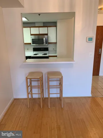 a view of room with wooden floor and flat screen tv