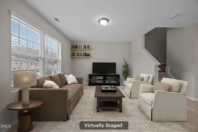 a living room with furniture a flat screen tv and a large window