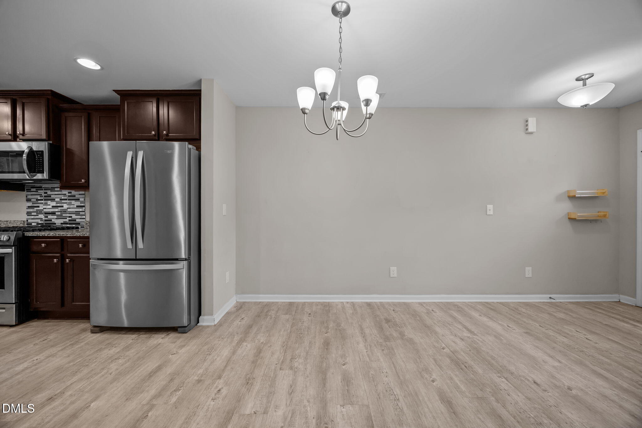 221 Socket Street Raleigh, NC 27606 - Photo 6 of 28 a view of a kitchen with a refrigerator a ceiling fan and a wooden floor