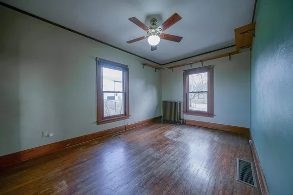 a view of wooden floor and a chandelier fan in a room