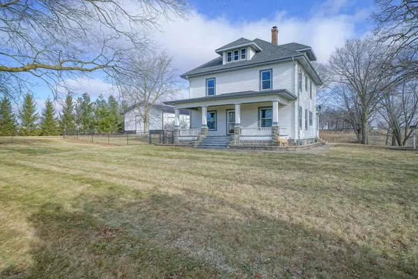 a house view with wooden fence and bench