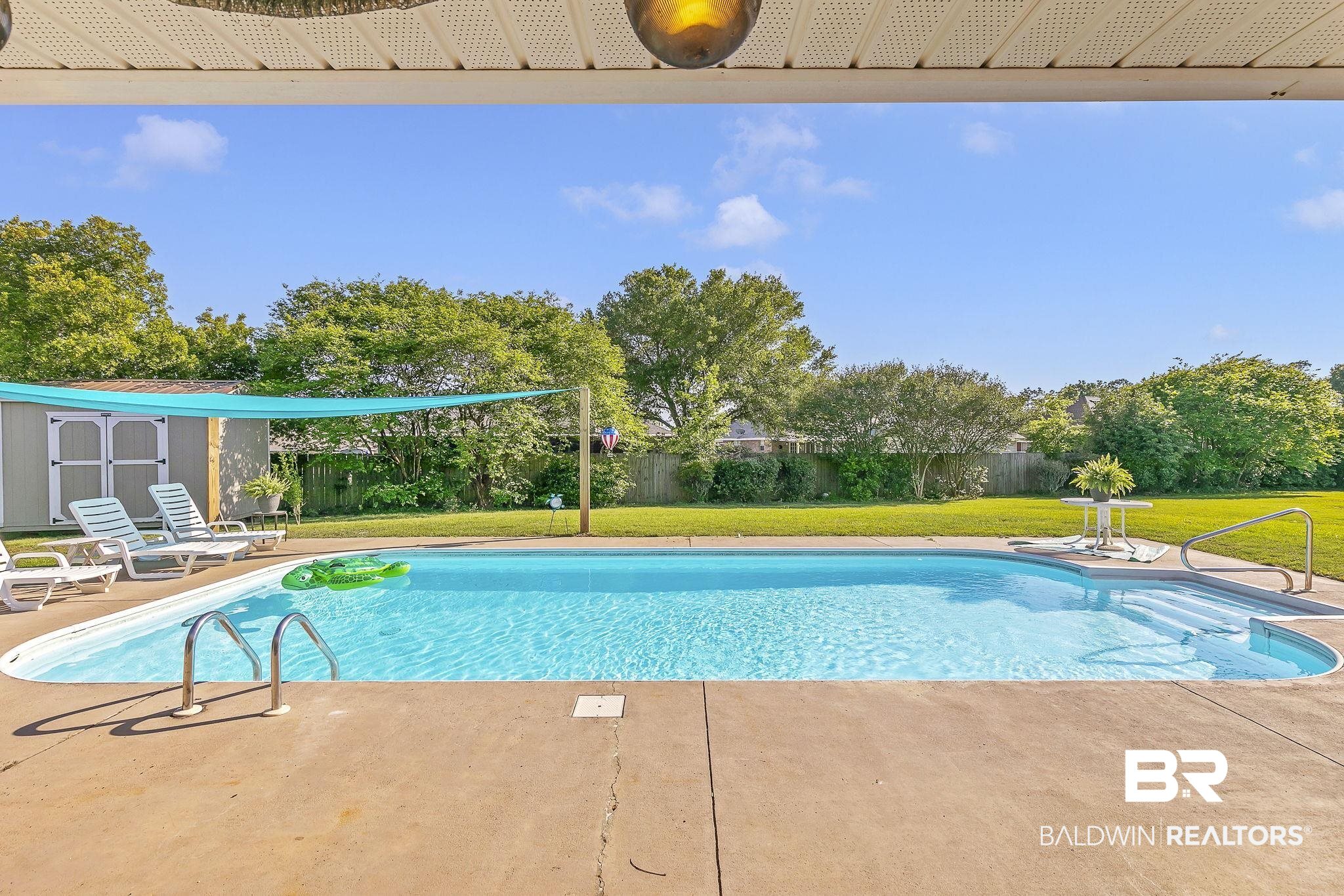 16358 Tempest Drive Foley, AL 36535 - Photo 35 of 46 View of swimming pool featuring a storage unit, a fenced in pool, a fenced backyard, a patio area, and a yard