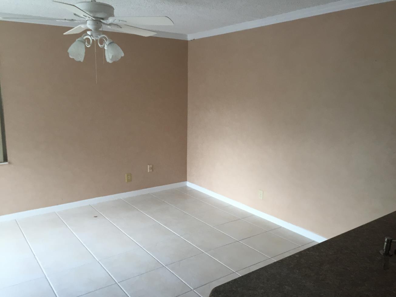 9276 Saddlebrook Drive Boca Raton, FL 33496 - Photo 7 of 10 an empty room with a chandelier fan and windows
