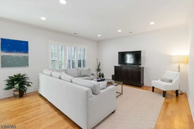 a open kitchen with stainless steel appliances granite countertop a stove top oven a refrigerator a dining table and chairs with wooden floor