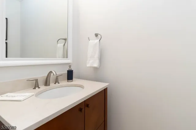 a kitchen with stainless steel appliances granite countertop a kitchen island a stove a refrigerator a sink a dining table and chairs with wooden floor