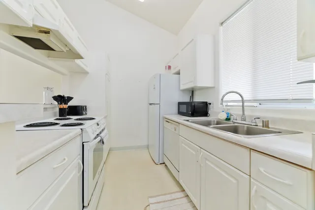 a kitchen that has a lot of cabinets in it and appliances