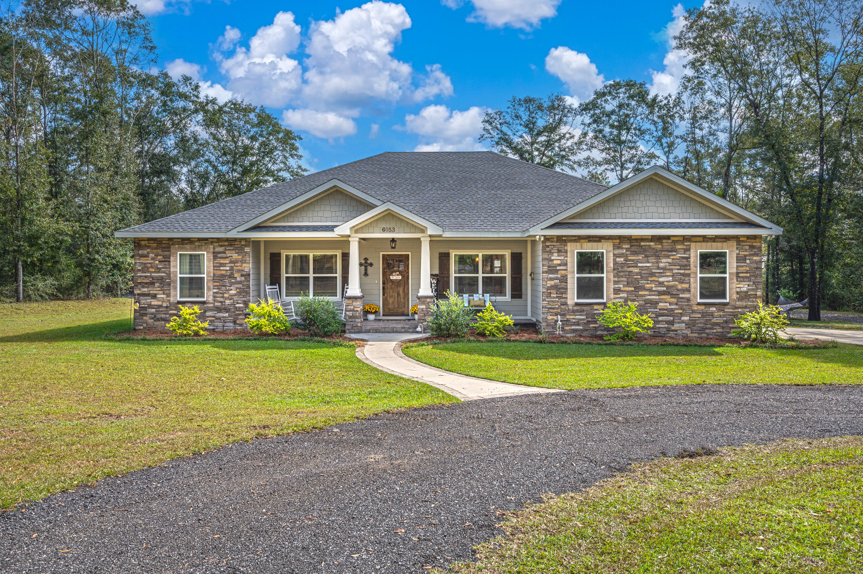 a front view of a house with a yard and trees