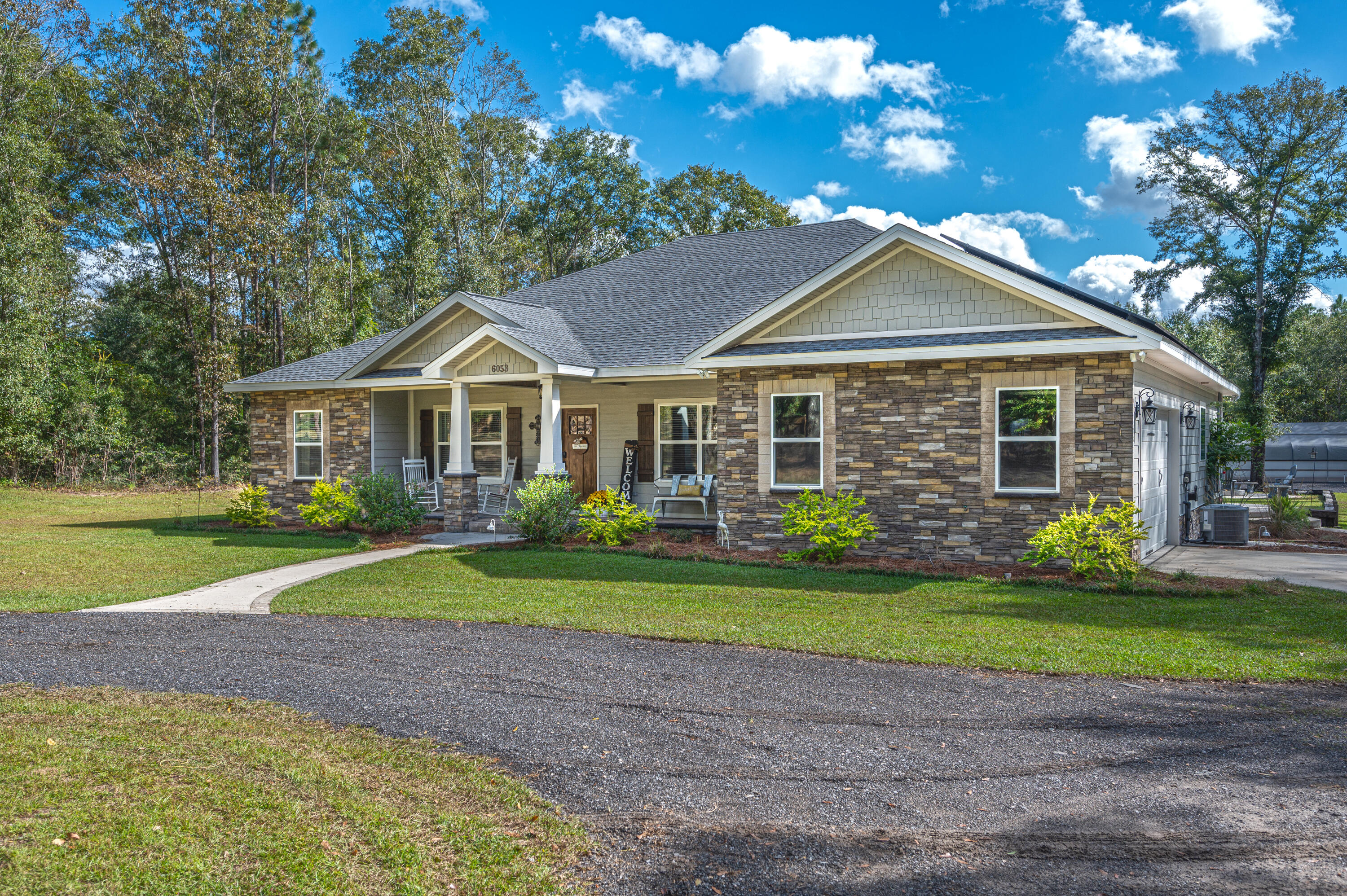 6053 Dairy Road Baker, FL 32531 - Photo 2 of 55 a front view of a house with a yard and garage