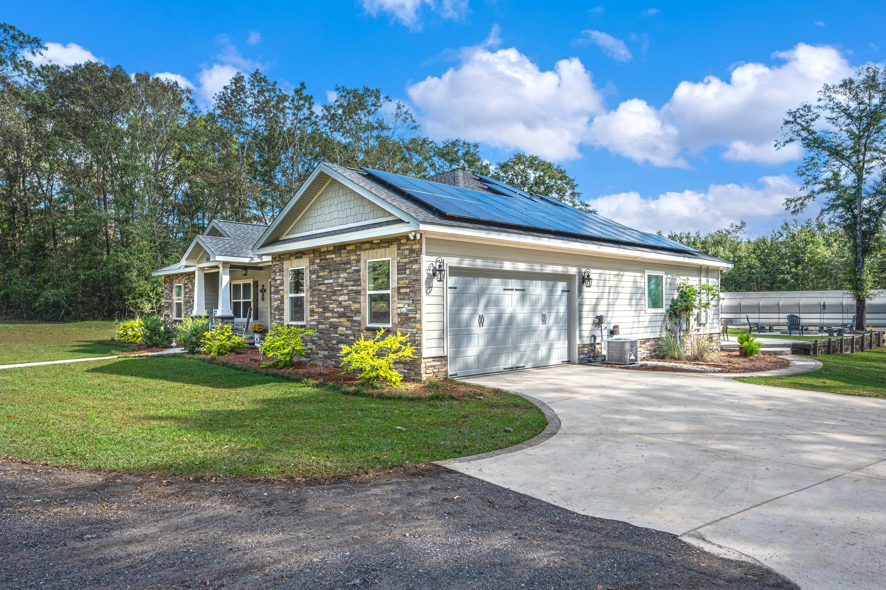 6053 Dairy Road Baker, FL 32531 - Photo 3 of 55 a front view of a house with garden and porch