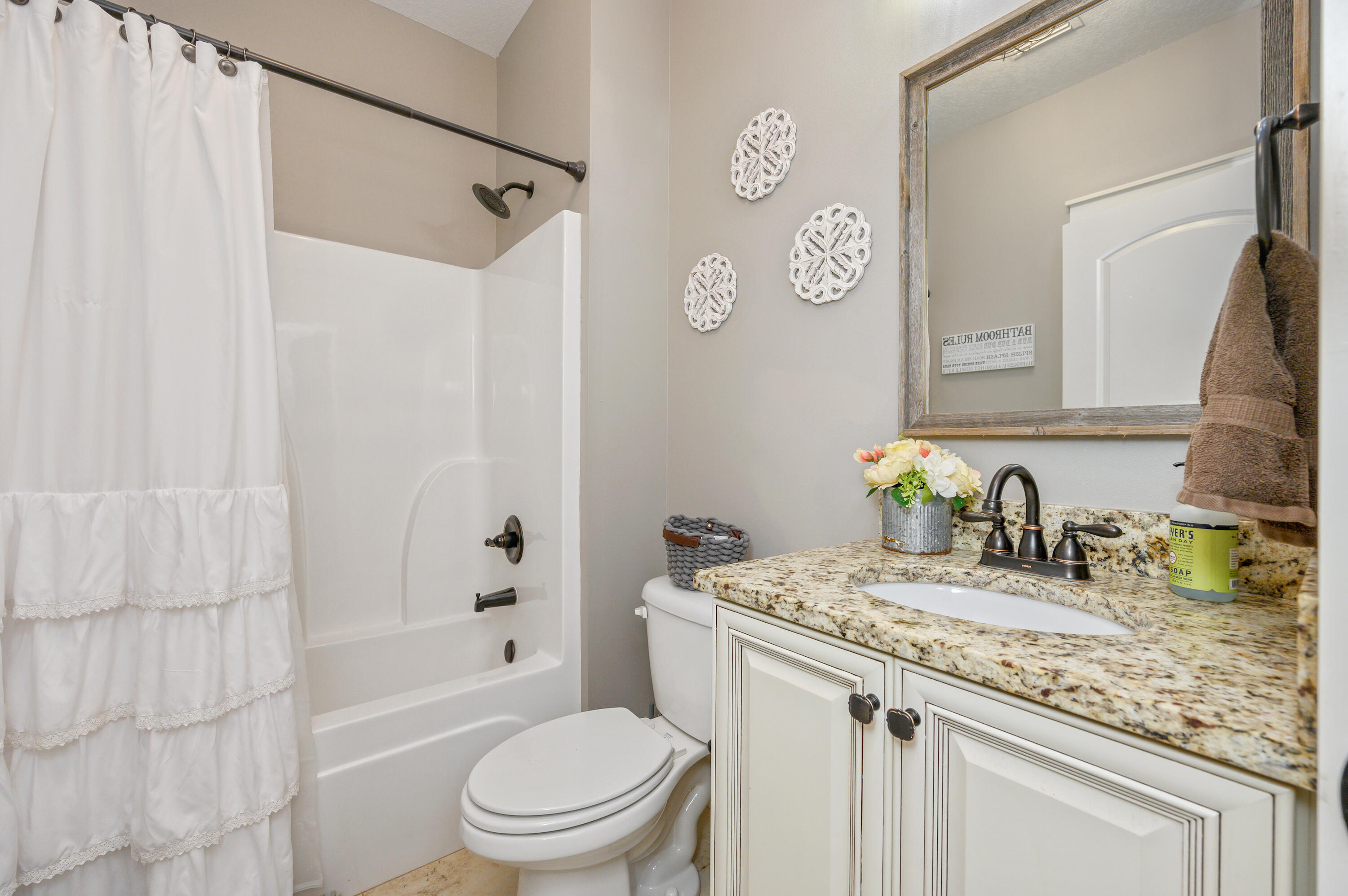 6053 Dairy Road Baker, FL 32531 - Photo 32 of 55 a bathroom with a granite countertop sink toilet and shower
