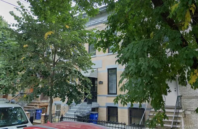 a view of a white house with a tree and a tree