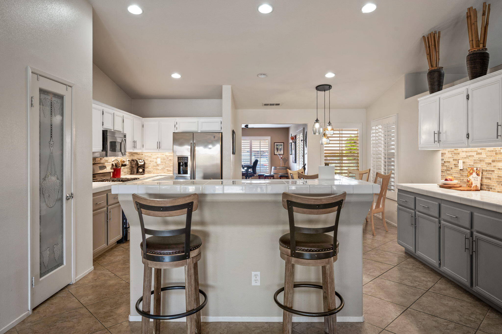 83414 Greenbrier Drive Indio, CA 92203 - Photo 14 of 43 a kitchen with stainless steel appliances granite countertop a table chairs stove and cabinets