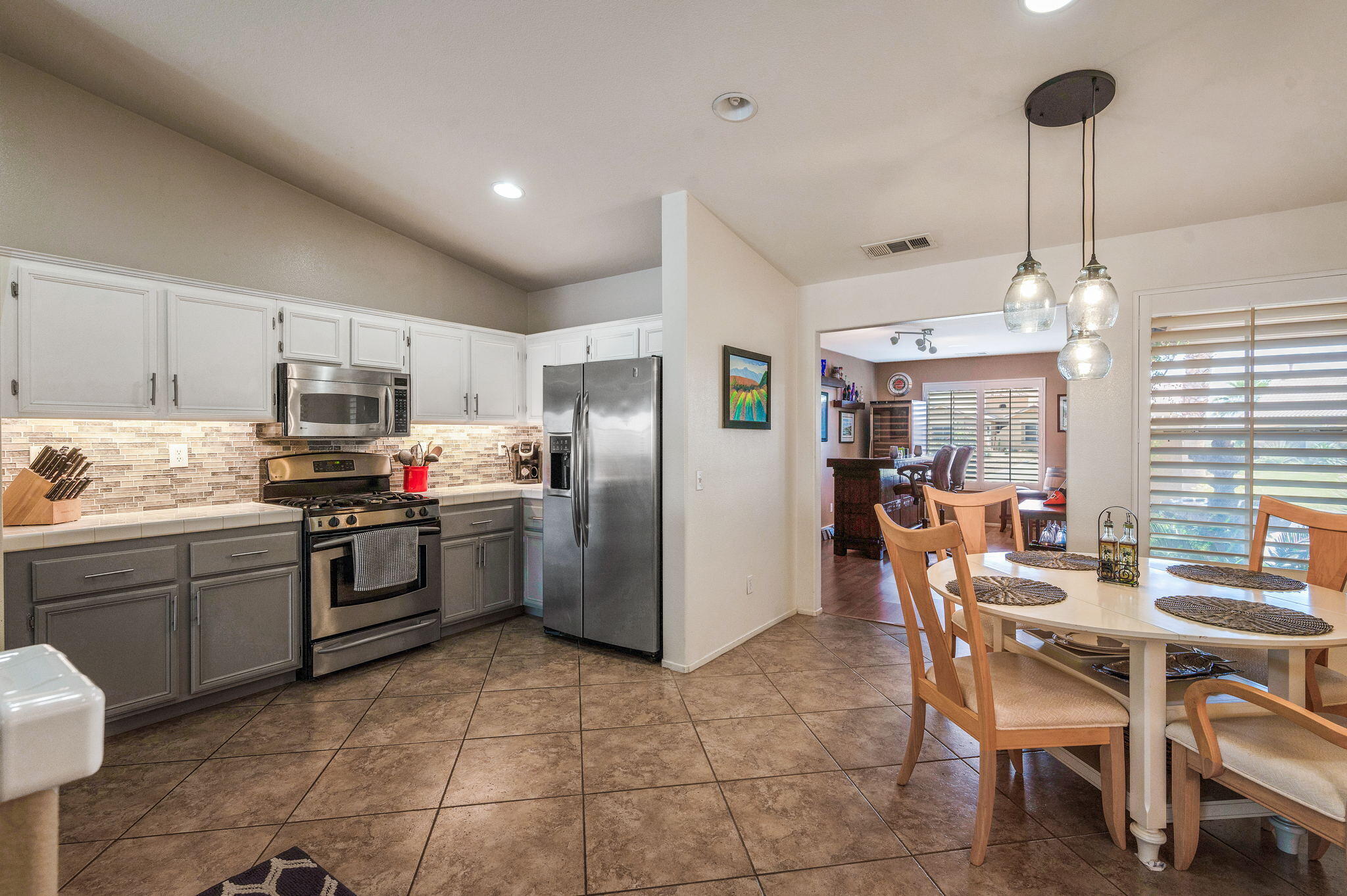 83414 Greenbrier Drive Indio, CA 92203 - Photo 17 of 43 a kitchen with refrigerator cabinets dining table and chairs