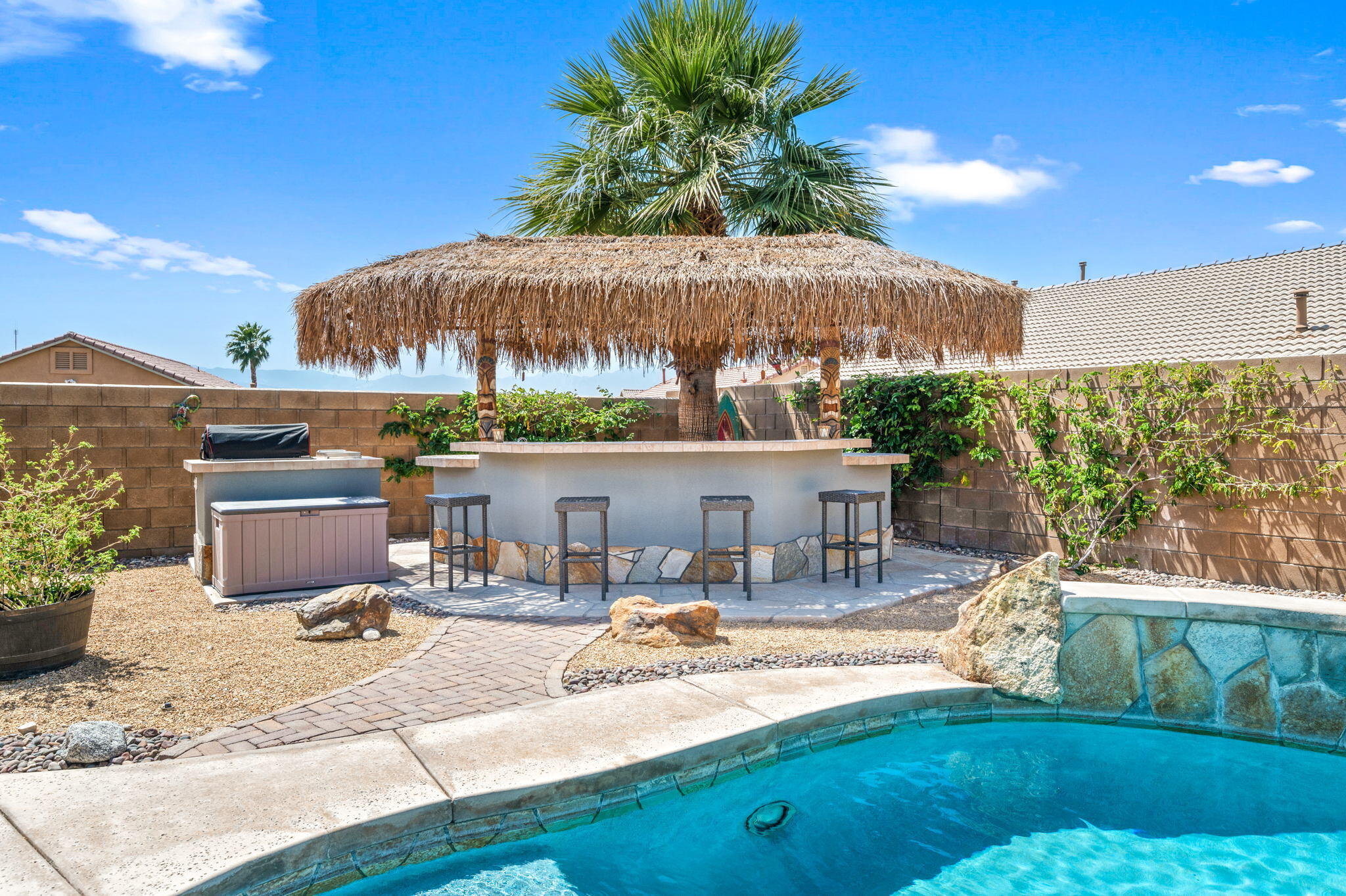 83414 Greenbrier Drive Indio, CA 92203 - Photo 36 of 43 a view of a patio with chairs and a table and chairs under an umbrella with a yard