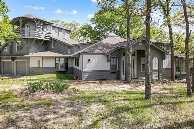 a view of a house with a yard and large tree