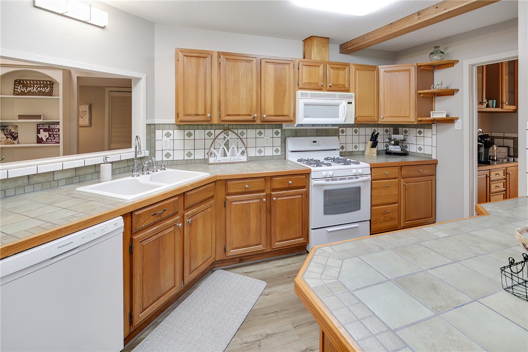 8010 Perry Lane College Station, TX 77845 - Photo 18 of 47 a kitchen with stainless steel appliances granite countertop a sink and cabinets